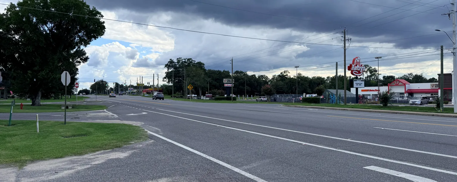 The US-90 commercial corridor through Chipley, Florida, under gathering storm clouds