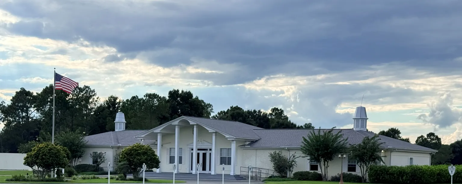 The clubhouse at Sunny Hills Golf Club in Sunny Hills, Florida, with its columned entrance and flagpole